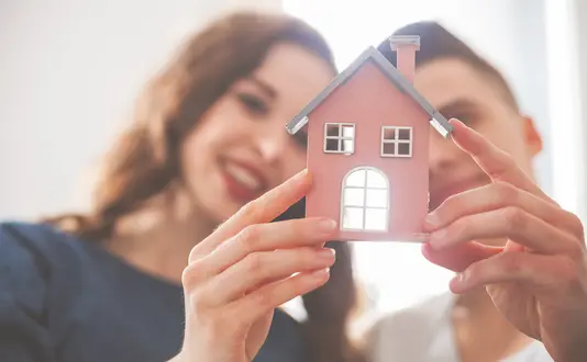 menschen-gemischt-paar-haelt-haus Paar
